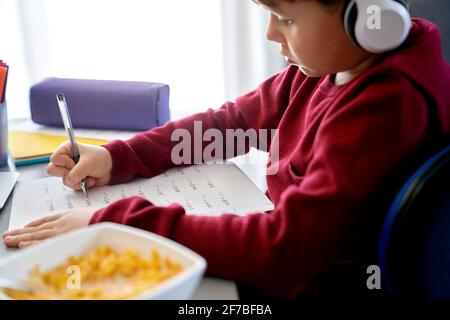 Close up side view of boy doing math homework Stock Photo