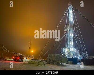 An oil rig in the north of Russia at night in winter on an illuminated site. Stock Photo