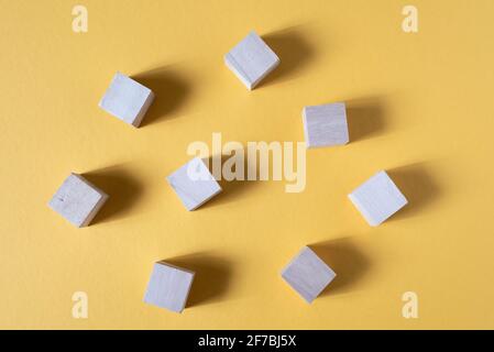 Blank wooden cube on a yellow backgorund. Concept of toys and teamwork Stock Photo
