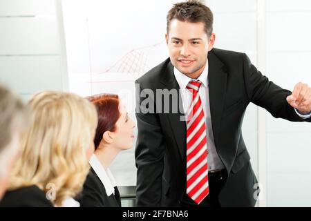 Business - presentation within a team, a colleague is explaining the strategy Stock Photo
