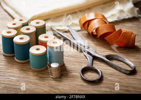 sewing tools : old scissors, bobbins with thread and needles on wooden ...