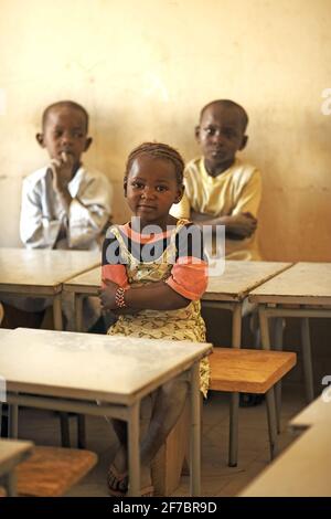 Children sitting on desks in a classroom in Mali, West Africa. Stock Photo