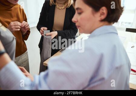 Person showing women a strip of fabric Stock Photo
