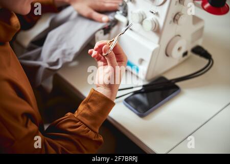 Dressmaker is showing embroidery scissors to camera Stock Photo