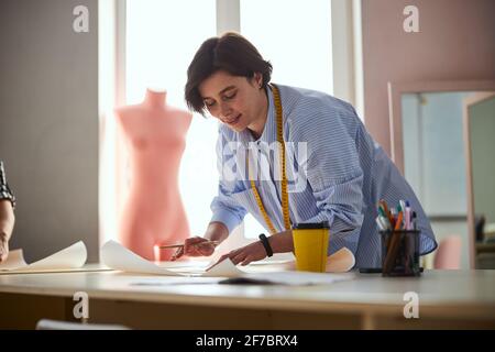 Tailor creating a dress design on paper piece Stock Photo