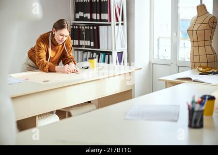 Lonely woman near table laying out her sketch on paper Stock Photo