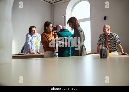 Two clothes designers wrapping a measuring tape on tailor dummy Stock Photo