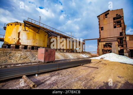 Demolition of outdated Soviet sulfuric acid plant industrial building. Outside view. Title on storage tank: Danger. Sulfuric Acid. Stock Photo