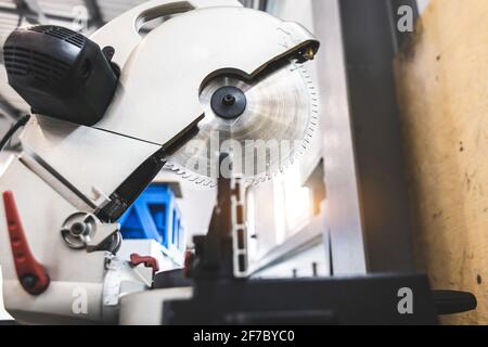 Carpenter cutting flaxboard using sliding compound mitre saw Stock Photo