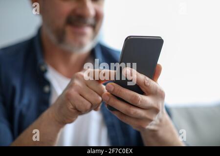 Unrecognizable matured man using modern mobile phone Stock Photo