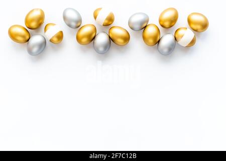 Silver and golden eggs isolated on white background. Easter decoration background. Top view Stock Photo