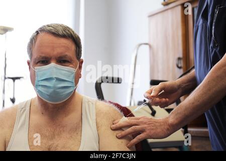Rheinbach, Germany. 06th Apr, 2021. Heribert Heimer (r) is vaccinated by his family doctor Oliver Funken. In North Rhine-Westphalia, Corona vaccinations have started in GP surgeries. Credit: Oliver Berg/dpa/Alamy Live News Stock Photo