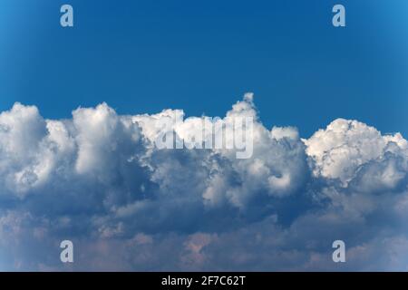 Beautiful storm clouds, cumulus clouds or cumulonimbus against a clear blue sky. Full frame, photography. Stock Photo