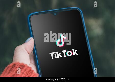 Podolsk, Ukraine - March 29, 2021: Smartphone in the hands of person who uses the Tik Tok application. Tiktok social network. logo of the current app Stock Photo