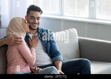 Happy middle-eastern family cuddling on couch at home Stock Photo