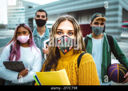 Portrait of a group of multiracial people covered by face masks - New normal lifestyle concept with students going to school - Vintage filter Stock Photo