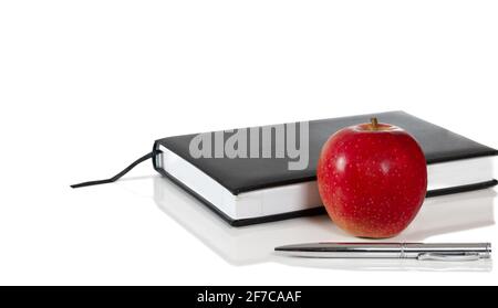 Red apple, book and pen isolated on white background. Healthy lifestyle and study concept. Stock Photo