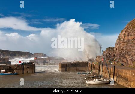 Stormy sea waves crash over the stone harbor wall at Burghead on the ...