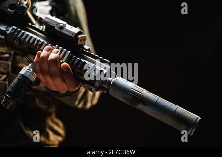 Unrecognizable special forces soldier standing with rifle against black dark background Stock Photo