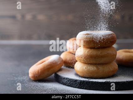 Sweet donuts with powder sugar on black background. Food concept. Copy space. Stock Photo