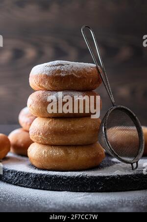 Sweet donuts with powder sugar on black background. Food concept. Copy space. Stock Photo