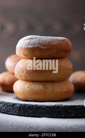 Sweet donuts with powder sugar on black background. Food concept. Copy space. Stock Photo