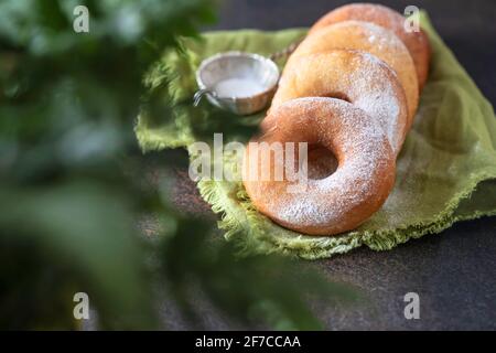 Sweet donuts with powder sugar on black background. Food concept. Copy space. Stock Photo