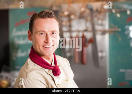 Working in a butchers shop - a butcher in his store Stock Photo