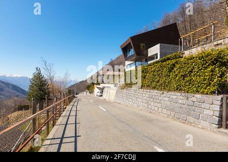 Exterior modern isolated villa, surrounded by nature. Iron and concrete cladding. Front road deserted. Nobody inside Stock Photo