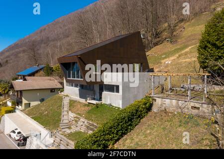 Exterior modern isolated villa, surrounded by nature. Iron and concrete cladding. Nobody inside. The place is in Canton Ticino, Switzerland. Stock Photo