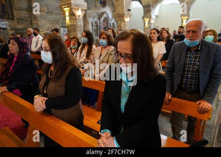 Iraqi Christians attend the Easter Mass at the Syriac Catholic Church of Mar Thomas in the old area of the city of Mosul, this mass is the only one this year in the old area (the right side of the city that was destroyed by the war) of the city of Mosul, which contains a large number of churches, most of which were destroyed by the organization ISIS during its occupation of the city, Mar Thomas Church is one of the city's churches that have been recently restored.Easter is considered as the greatest and the largest Christian holiday, it commemorates the resurrection of Christ from the dead aft Stock Photo