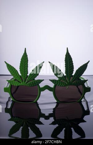marijuana sunglasses on water advertising photo green sunglasses with marijuana leaf elements, isolate on white background Stock Photo