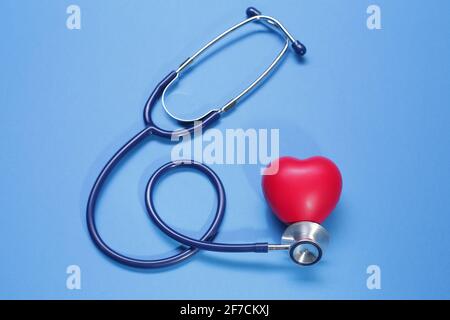 Red heart shape and stethoscope on blue background Stock Photo