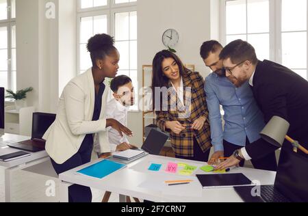 Smiling multiethnic business team with marker pen and stickers working in office Stock Photo