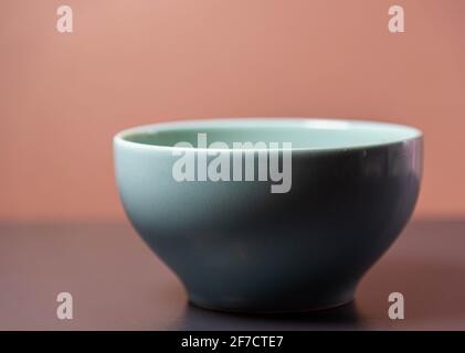 Porcelain canister on brown and dark background. Vase for storing liquids; canister. Container used to condition, to store food. Stock Photo