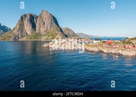Colorful fisherman's wooden houses in village of Reine in Lofoten in the golden hour during sunset. Beautiful sunny afternoon in the arctic. Arctic su Stock Photo
