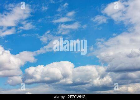 Soft white clouds gather in gray clouds against the blue sky. Copy space. Stock Photo