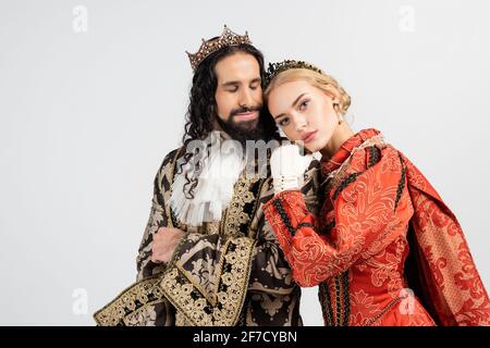 interracial king and queen in medieval clothing and crowns hugging isolated on white Stock Photo