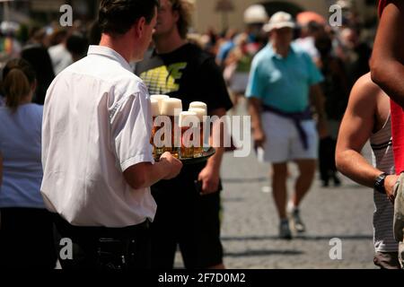 An ordinary sight in Prague. Waiter carrying full beer glasses