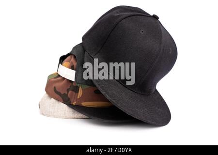 Four baseball snapback hats in different colors stacked on top of each other, isolated on white background. Stock Photo