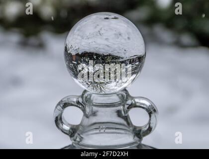 snowy garden scene reflected upside down in a crystal ball Stock Photo