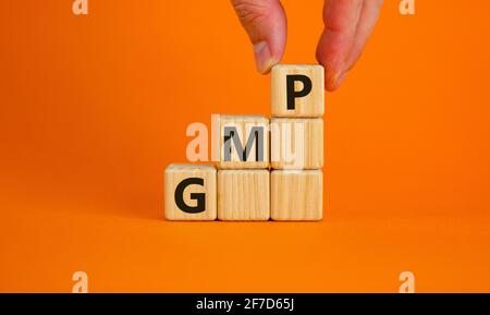 GMP, good manufacturing practice symbol. Concept words GMP, good manufacturing practice on cubes on a beautiful orange background. Business and GMP, g Stock Photo