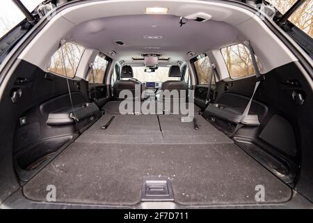 rear view open car trunk with folded passenger seats. large empty flat flor car trunk close up. huge suv trunk. Stock Photo