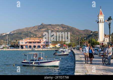 Zakynthos, Greece - August 14, 2016: People walk the coast of Zante port near moored fishing boats Stock Photo