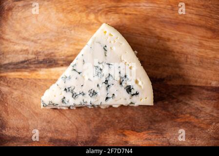A piece of blue cheese, cheese with mold on wooden texture. French traditional food. Top view Stock Photo