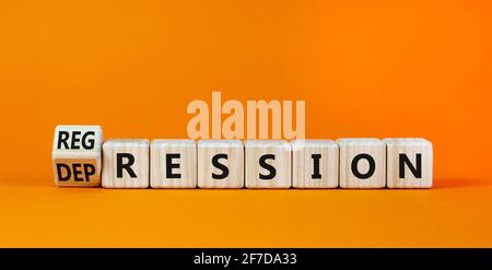 Depression or regression symbol. Turned cubes and changed the word 'depression' to 'regression'. Beautiful orange background. Psychological, depressio Stock Photo