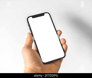 Kharkov, Ukraine - April 3, 2021: Man holding Apple iPhone 12, with white screen Stock Photo