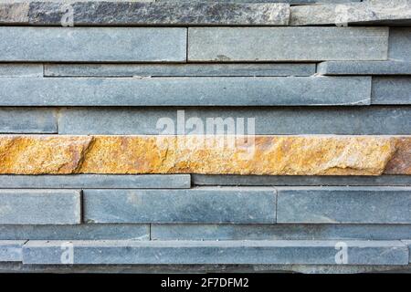 A modern stone wall made of long large cuts of stones. Stock Photo