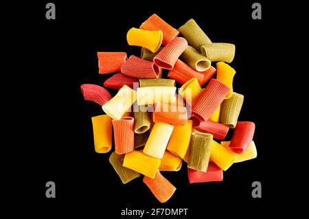 Assorted multicolored ones in rigatoni. Grocery food background, isolated on a black background. Top view. Stock Photo