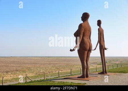 Waiting for high tide is a statue of Jan Ketelaar on the seawall near Holwerd. The two welded metal, five meters high women look out over the sea. Stock Photo